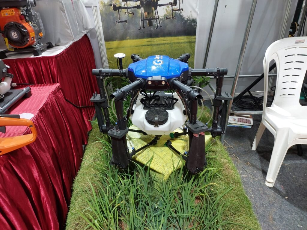 An agricultural multi-rotor drone in flight, the same general airframe class adapted for pollen dispersal in orchard pollination trials