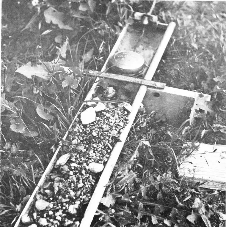 Black-and-white USDA photo of a four-inch eaves trough filled with coarse gravel, fed by a float water-level valve