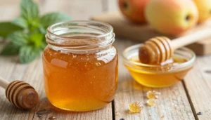 A close-up view of a jar of crystallized honey, showcasing its beautiful, shimmering golden texture with glistening sugar
