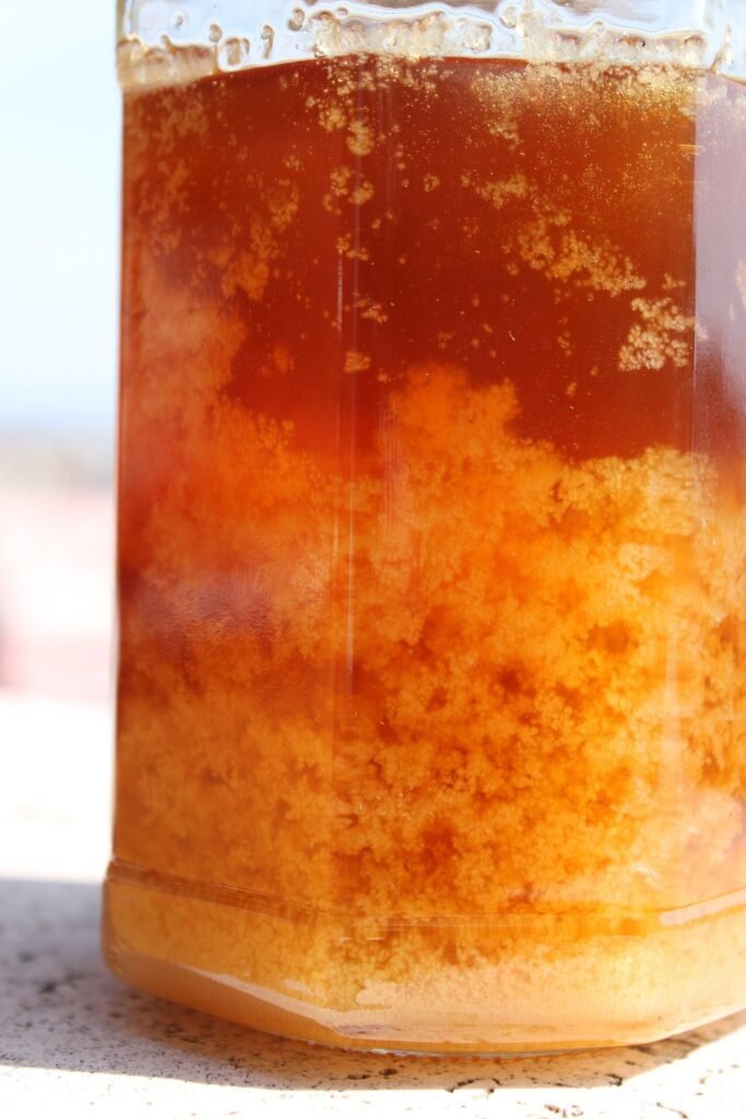 Photo of a jar of granulating honey with a crystallized mass below and a layer of liquid honey above