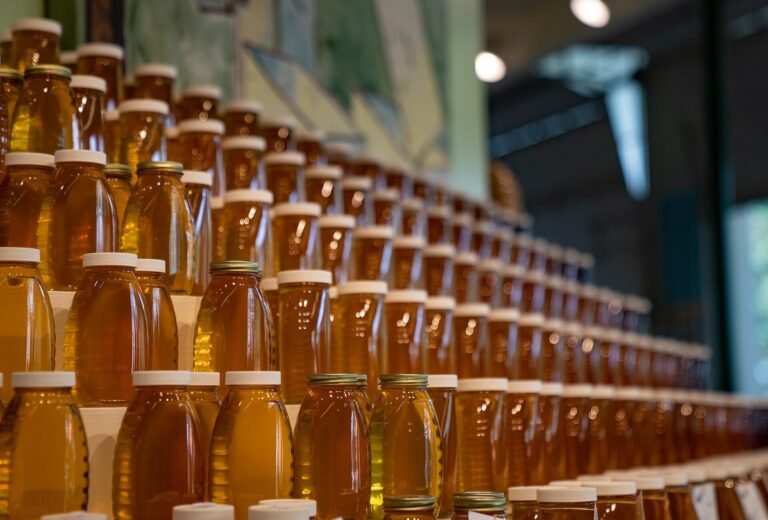 Photo of rows of bottled liquid honey in glass jars on tiered display shelves at the Minnesota State Fair