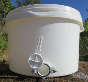 Photo of a white food-grade plastic honey tank with a plastic honey gate fitted near its base