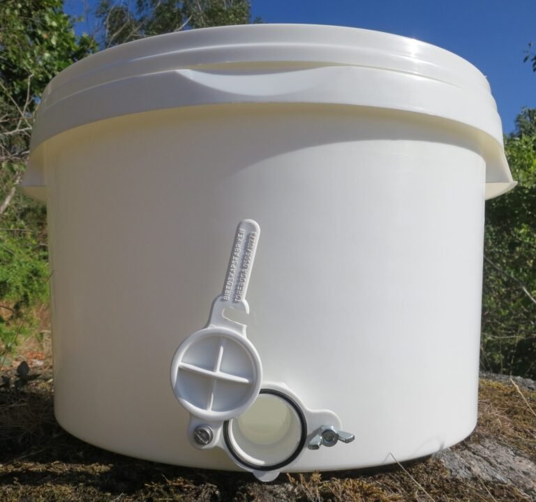 Photo of a white food-grade plastic honey tank with a plastic honey gate fitted near its base
