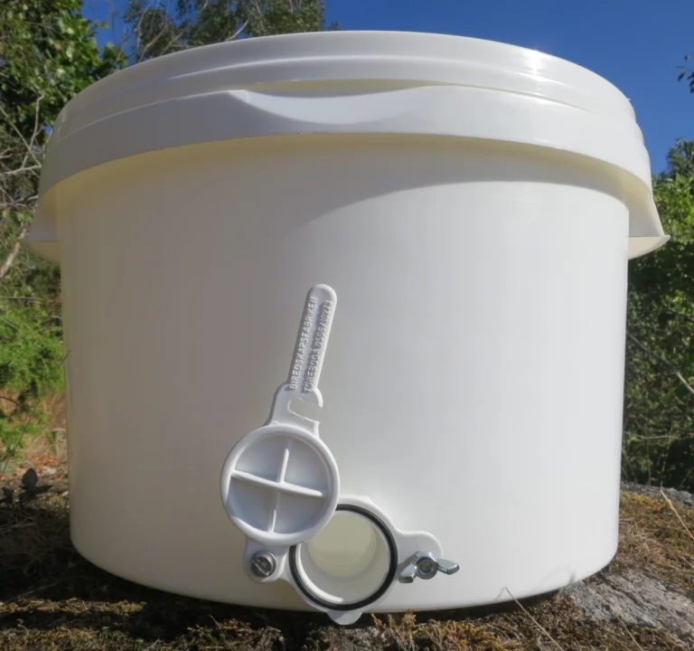 Photo of a white food-grade plastic honey tank with a plastic honey gate fitted near its base