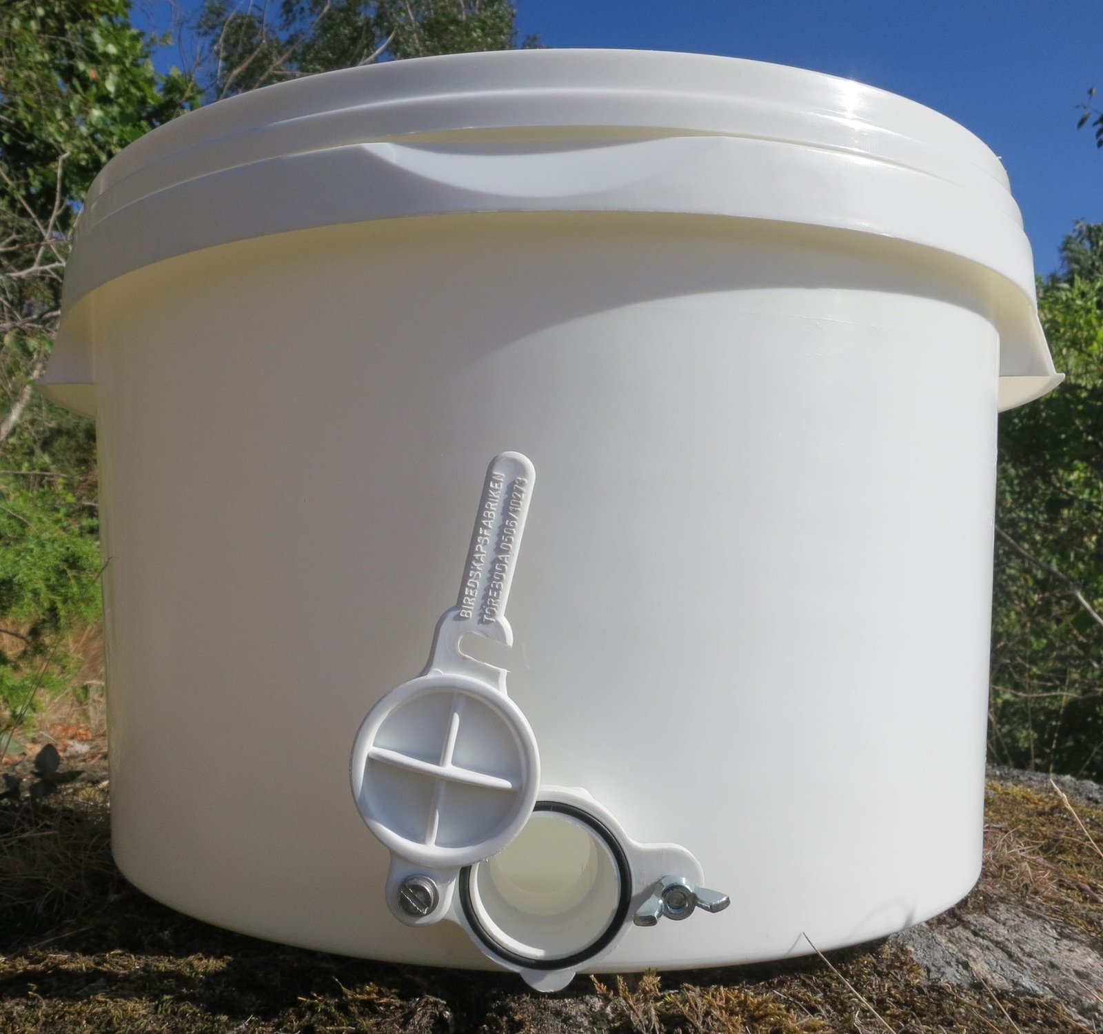 Photo of a white food-grade plastic honey tank with a plastic honey gate fitted near its base