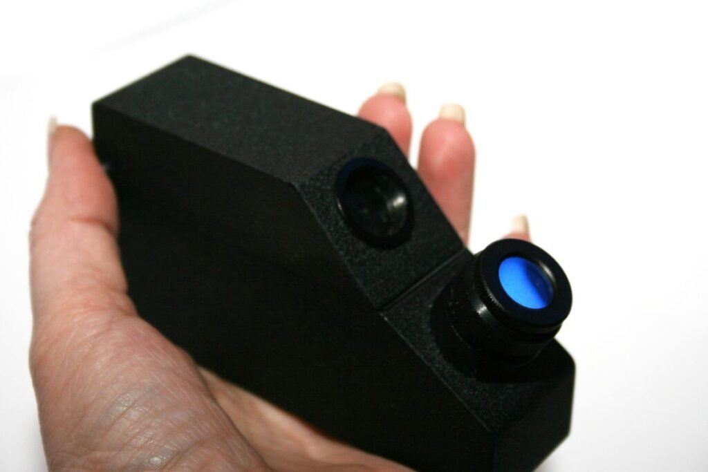 A handheld optical refractometer with its eyepiece and calibrated scale visible, the analog design VEE GEE's and Misco's non-digital honey refractometers are based on