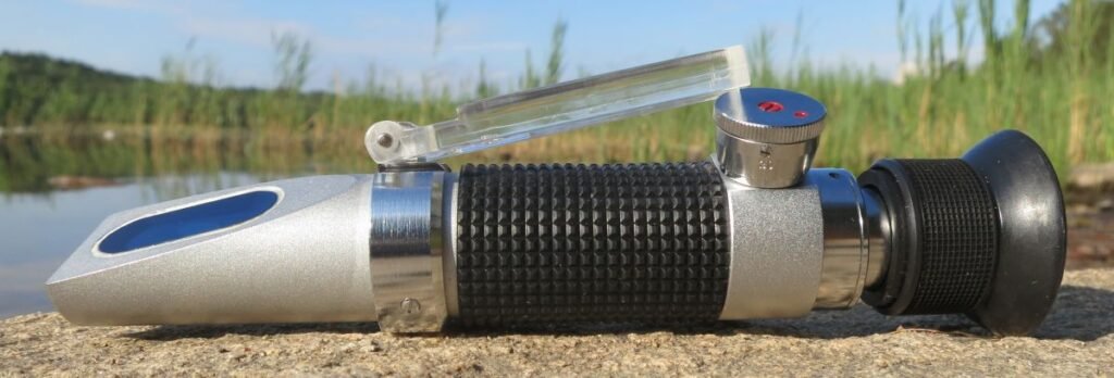A portable handheld honey refractometer used to measure moisture content by refraction, the same basic optical principle VEE GEE, Atago, and Misco models all use