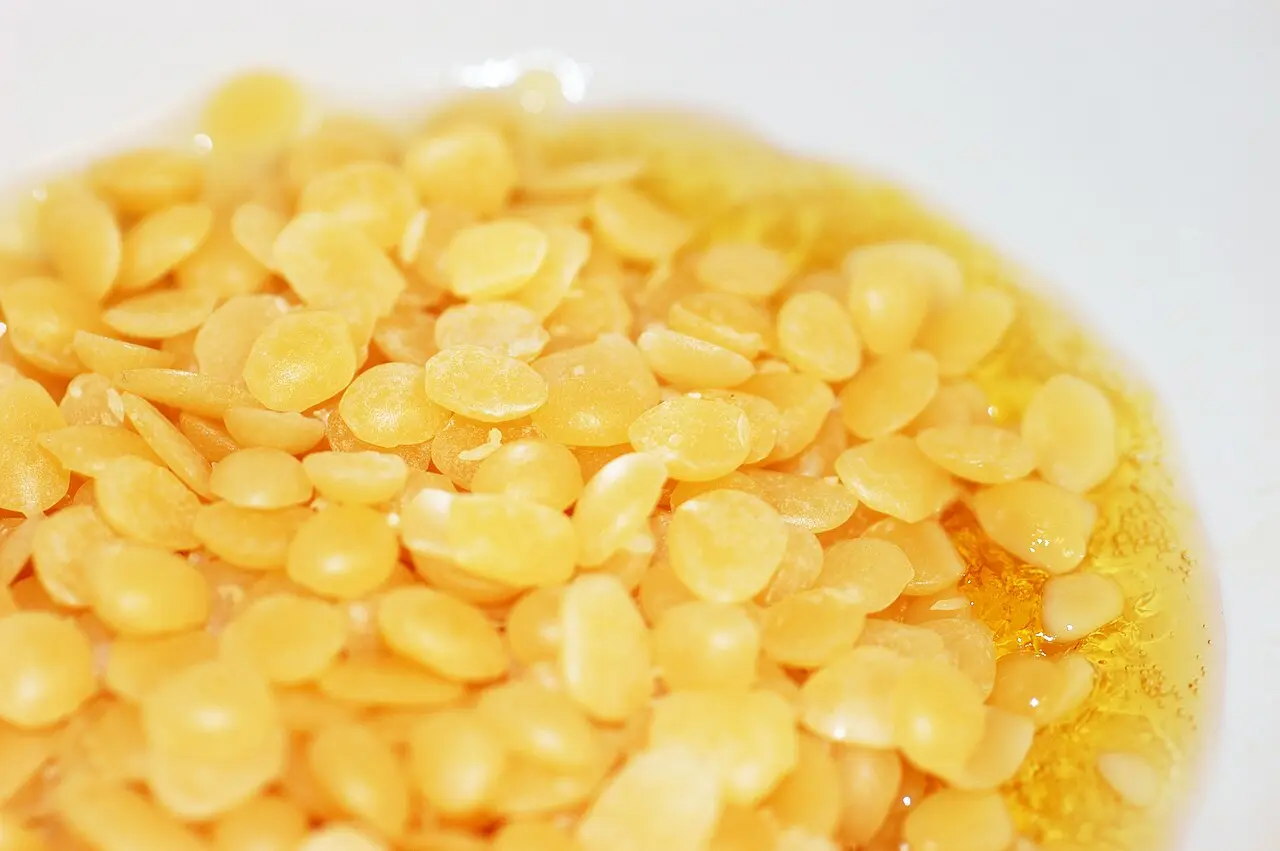 Beeswax pellets melting in a metal pan, the first step in making lip balm