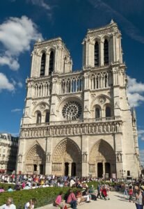 Notre-Dame Cathedral west facade with twin Gothic towers under blue sky in Paris
