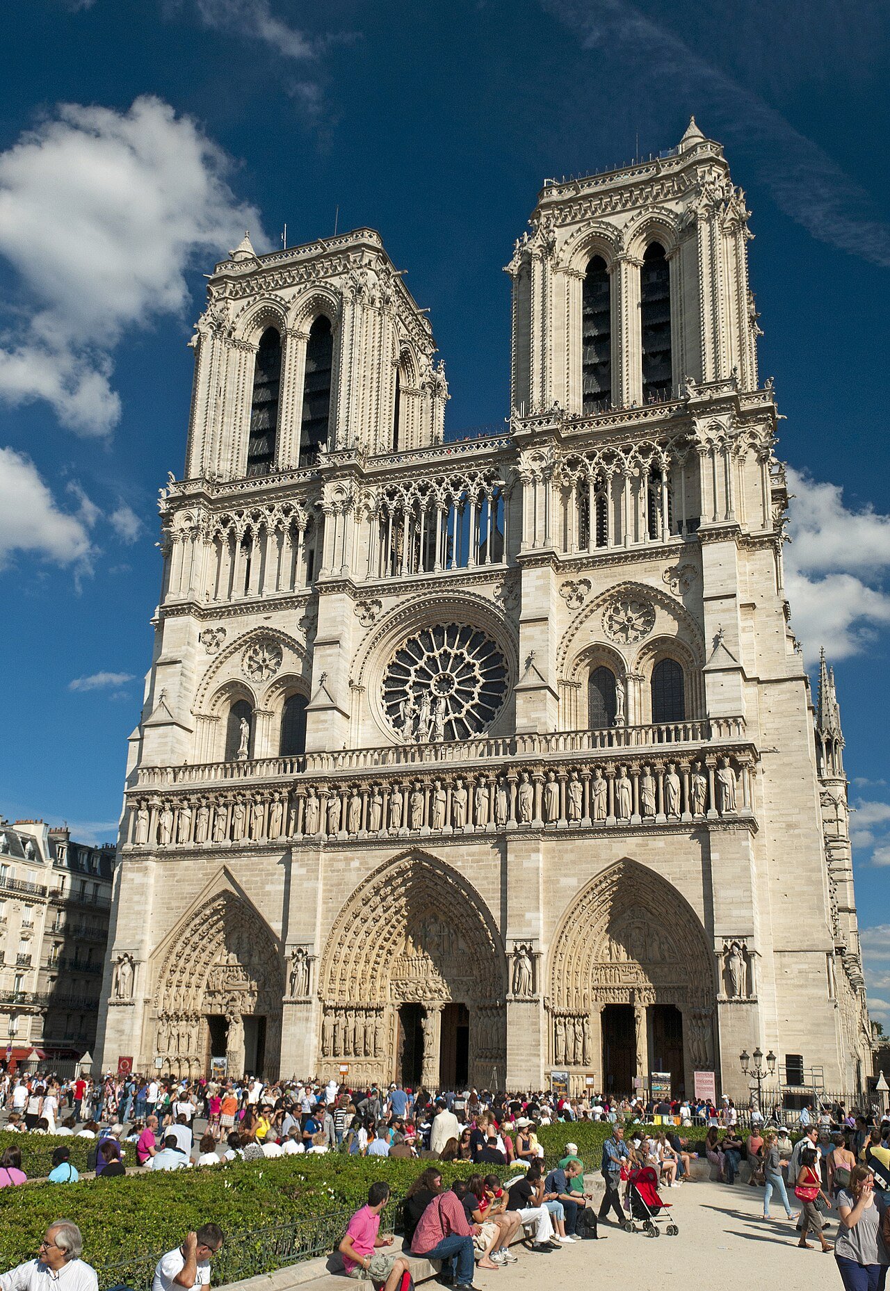 Notre-Dame Cathedral west facade with twin Gothic towers under blue sky in Paris