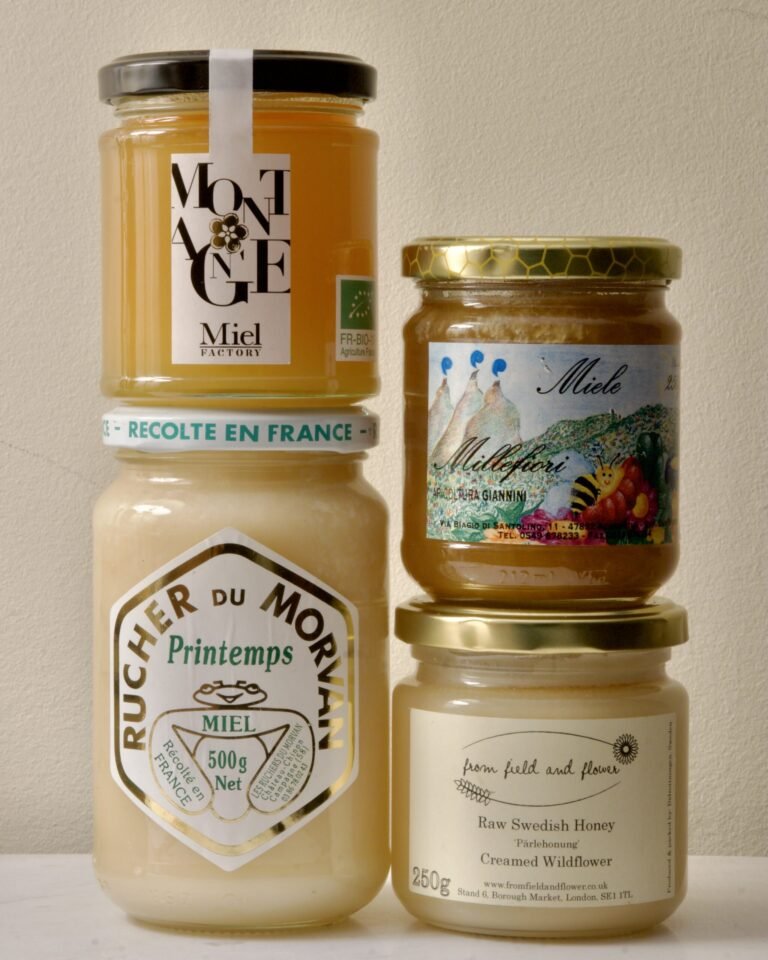 A selection of creamed honey jars from European producers, showing the smooth opaque texture of properly seeded honey