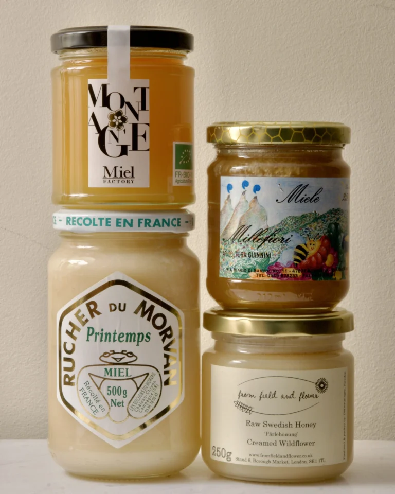 A selection of creamed honey jars from European producers, showing the smooth opaque texture of properly seeded honey