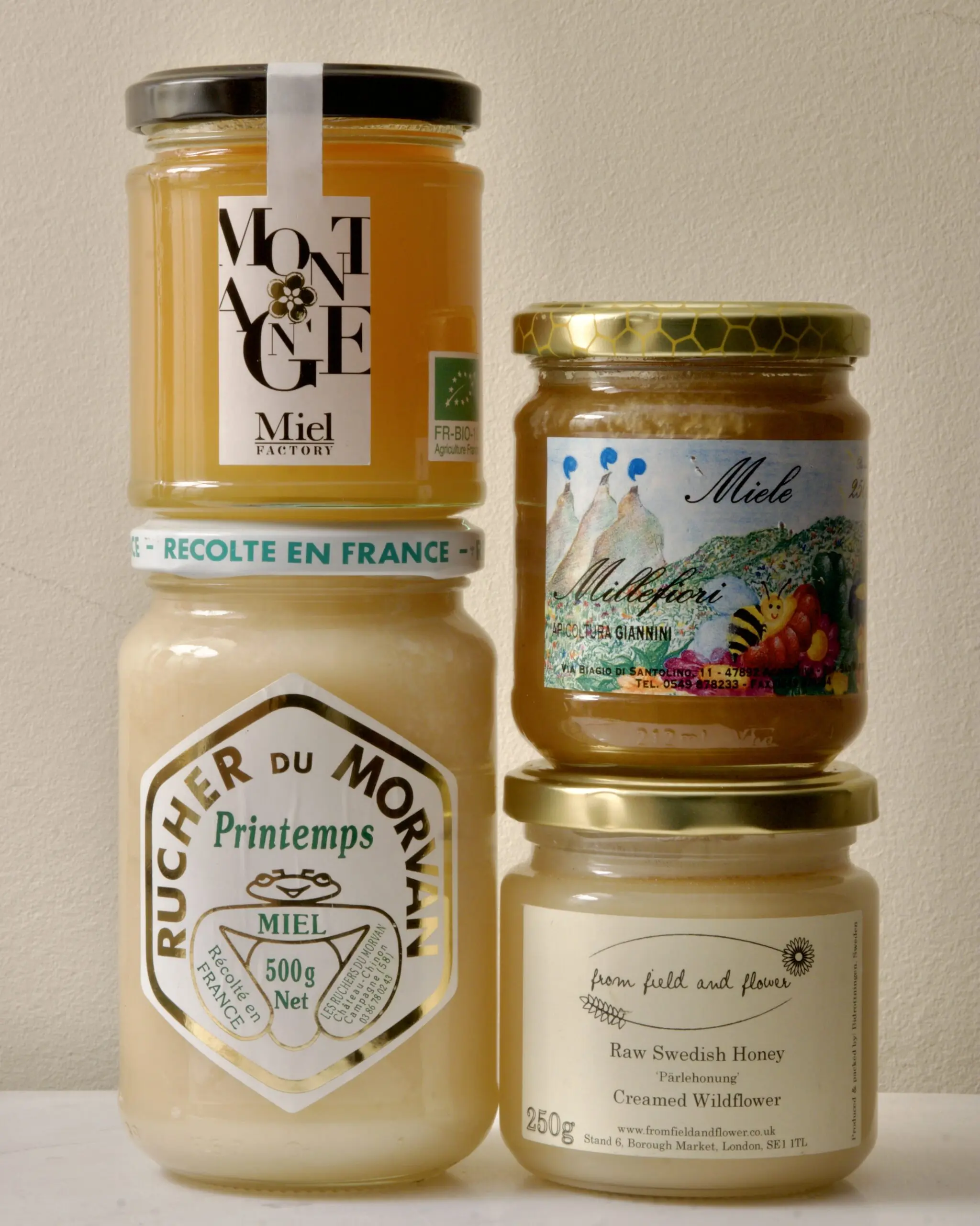 A selection of creamed honey jars from European producers, showing the smooth opaque texture of properly seeded honey