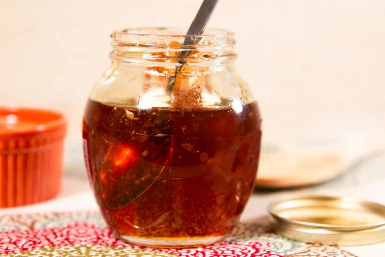 Small glass honey jar with a piece of honeycomb inside, the mini-jar size often used for wedding favors