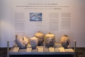 Museum exhibition panel titled It Is the Land of Honey displaying ancient storage jars and an aerial photo of the Tel Rehov excavation site in Israel