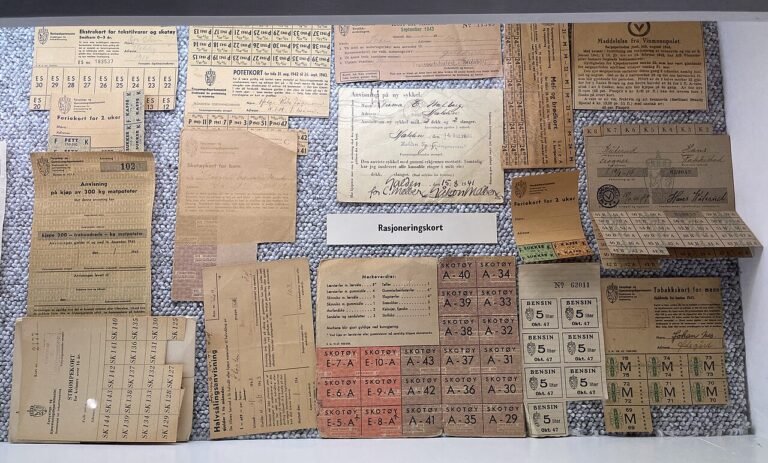 A museum display of worn World War II-era ration cards and stamps for sugar, shoes, textiles, and other goods