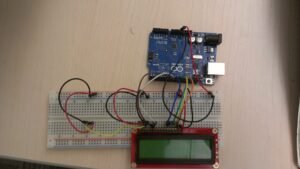 Arduino microcontroller wired to a breadboard and LCD display, the kind of electronics used in DIY hive-monitoring builds