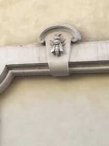 Carved stone Barberini bee emblem set into a Rome building facade