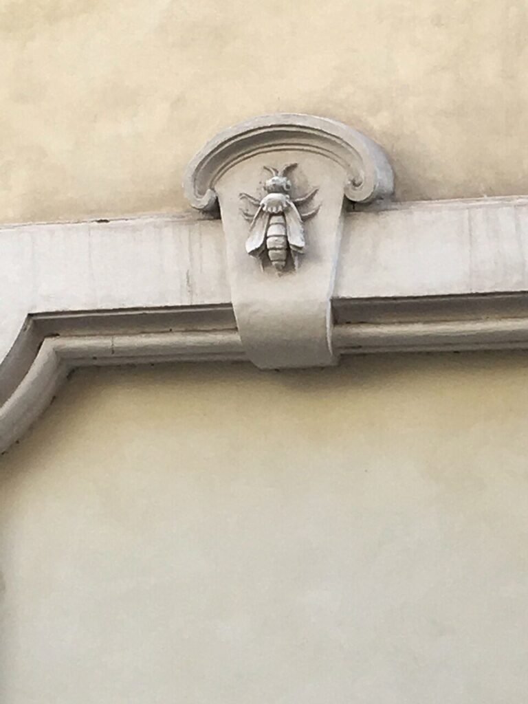 Carved stone Barberini bee emblem set into a Rome building facade