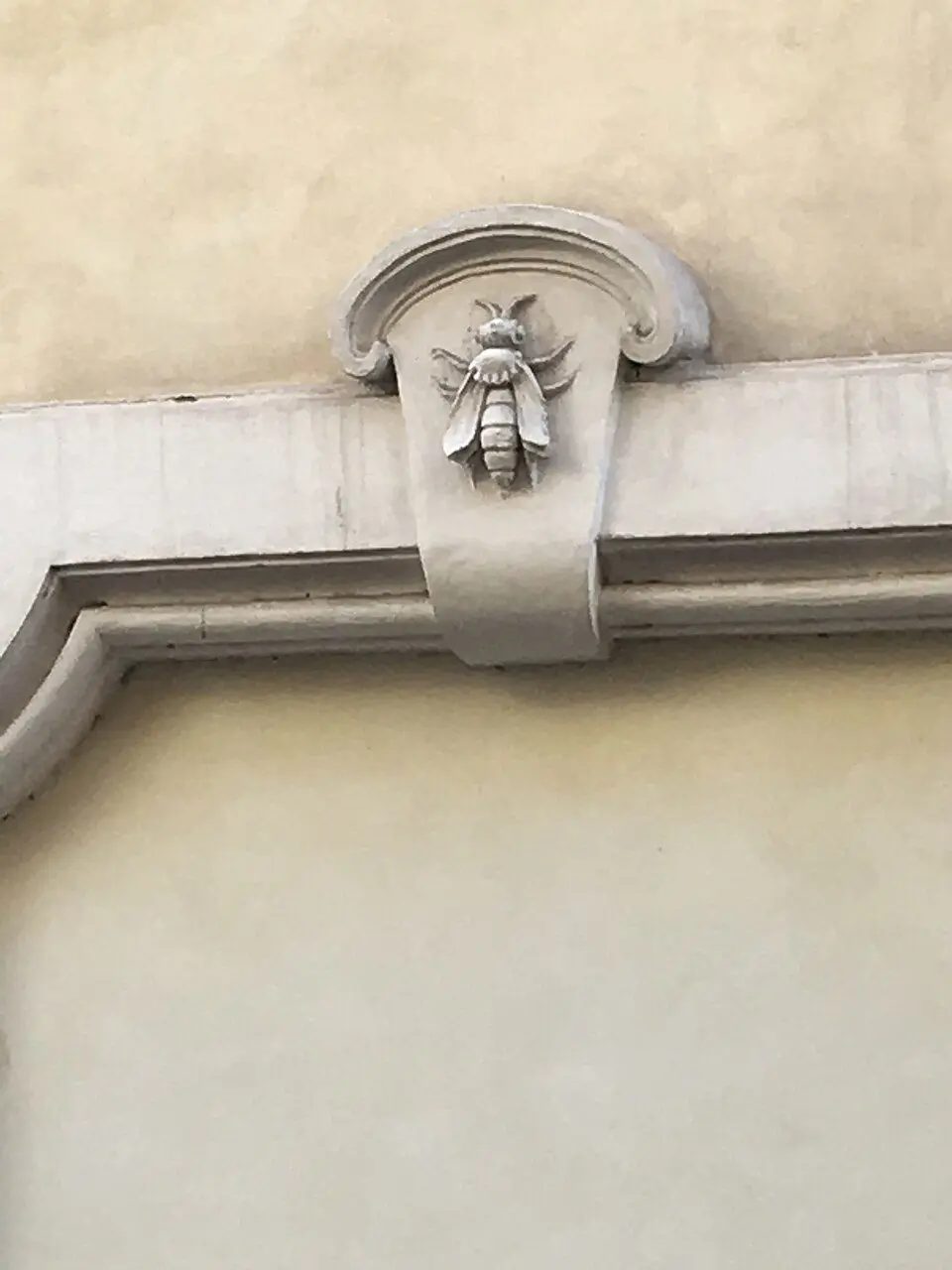 Carved stone Barberini bee emblem set into a Rome building facade