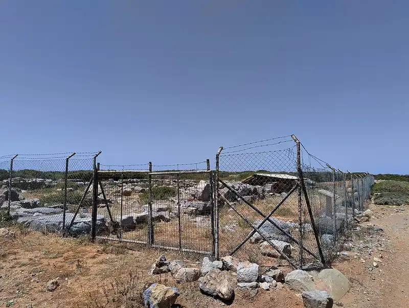Low stone ruins of the Chrysolakkos burial enclosure near Malia on Crete, where the pendant was excavated