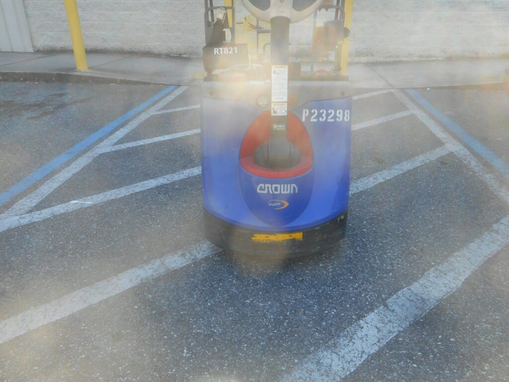 An electric pallet jack of the type used to move palletized loads, including hive pallets, quickly at commercial scale