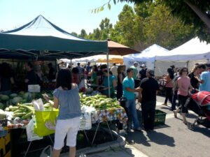 A weekly outdoor farmers market, one of the direct-to-consumer channels small honey producers use to sell honey