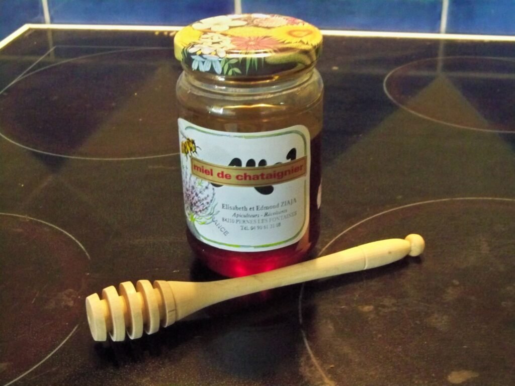 A jar of honey with a wooden dipper, the kind of product that shifts insurance needs into business liability territory once sold