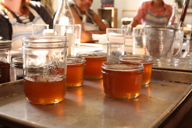 Jar of homemade jelly on a table, the kind of preserve homesteaders sweeten partly with honey