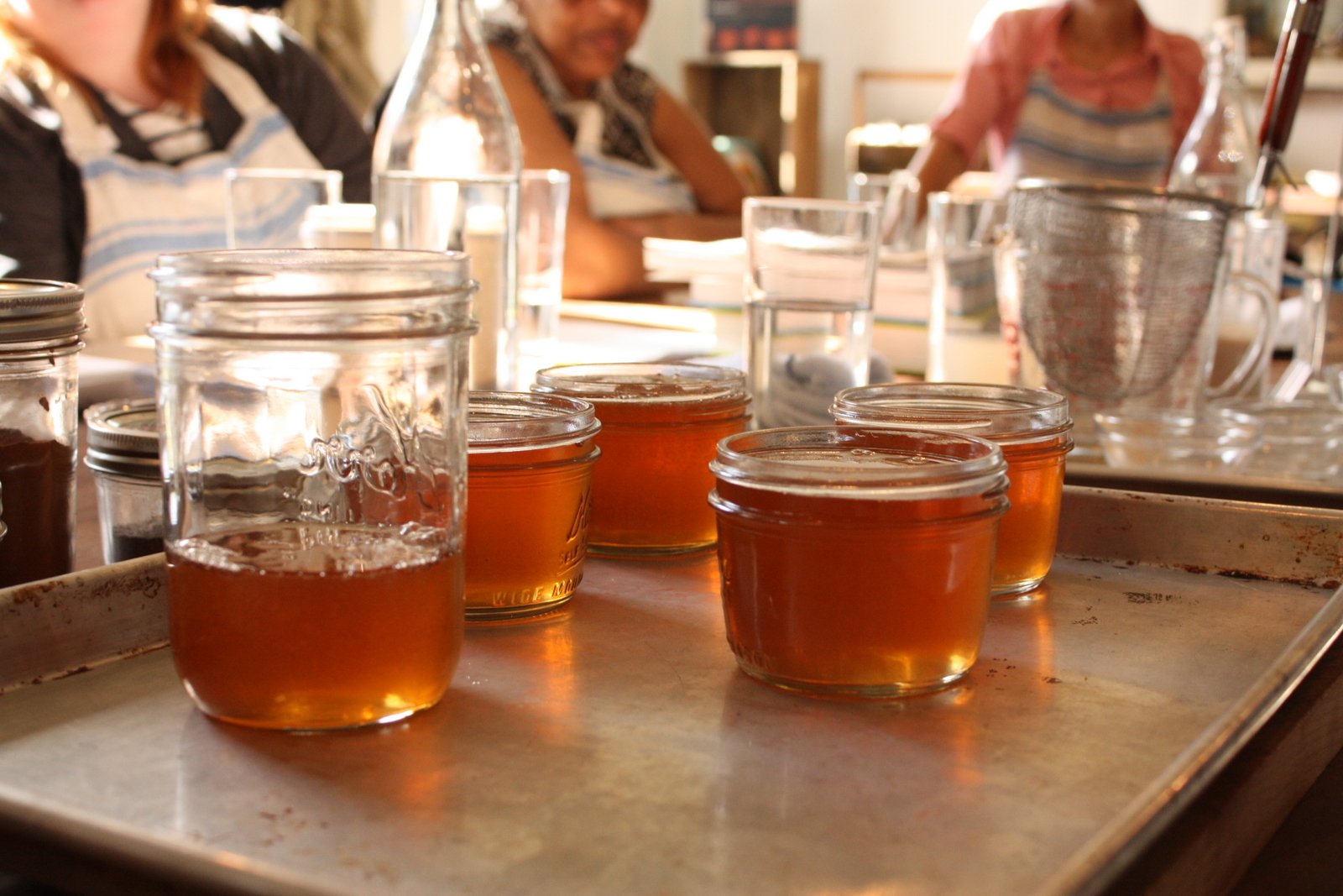 Jar of homemade jelly on a table, the kind of preserve homesteaders sweeten partly with honey
