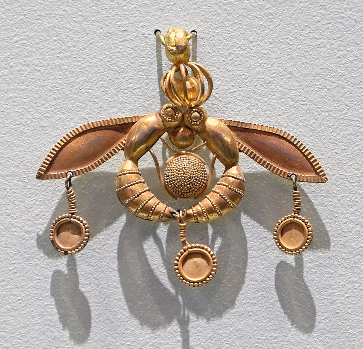 Ancient gold Malia Pendant showing two bees holding a honeycomb, Heraklion Museum