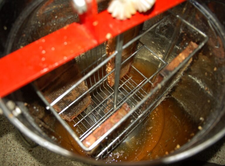 Manual hand-crank honey extractor drum used to spin honey from frames without electricity