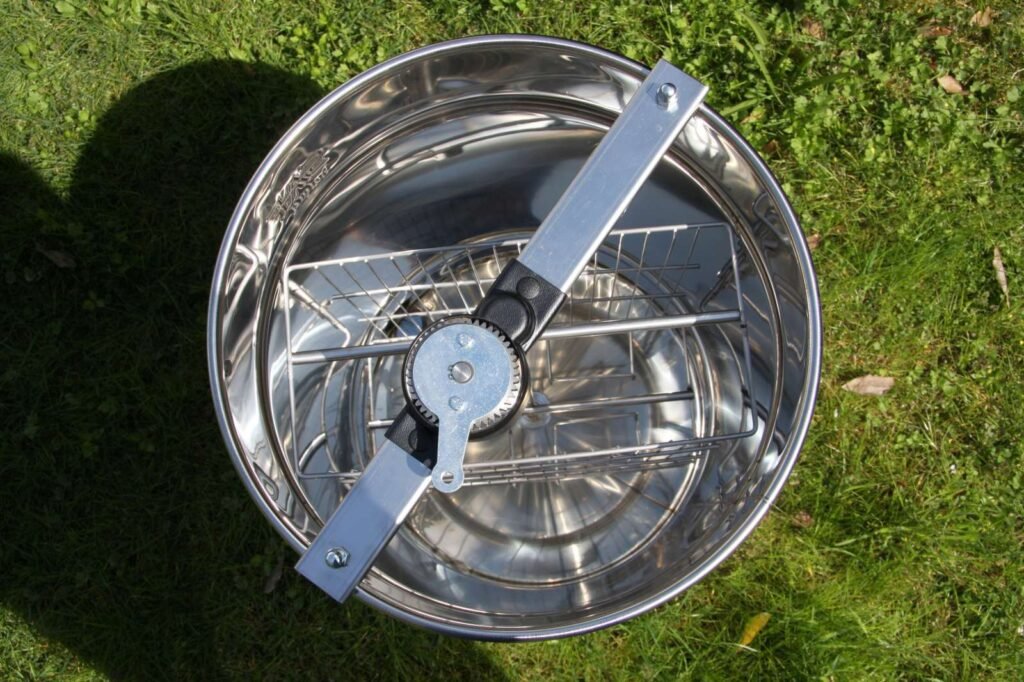 A modern stainless steel four-frame honey extractor of the type widely used by beekeepers today