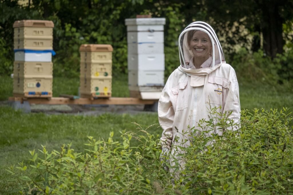 Beekeeper working a backyard hive alone, illustrating the placement decisions that matter most with young kids nearby