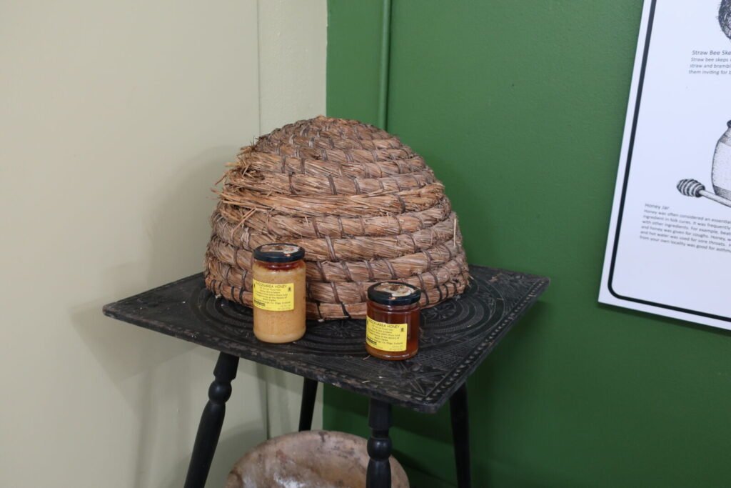 A preserved traditional straw skep beehive on display at a folk heritage museum