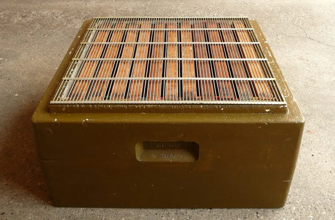 Wire mesh queen excluder placed on top of a hive box, the type of barrier used to contain Warwick Kerr's imported African queens before their 1957 escape
