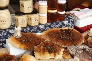 Jars of raw honey displayed for sale on a vendor table