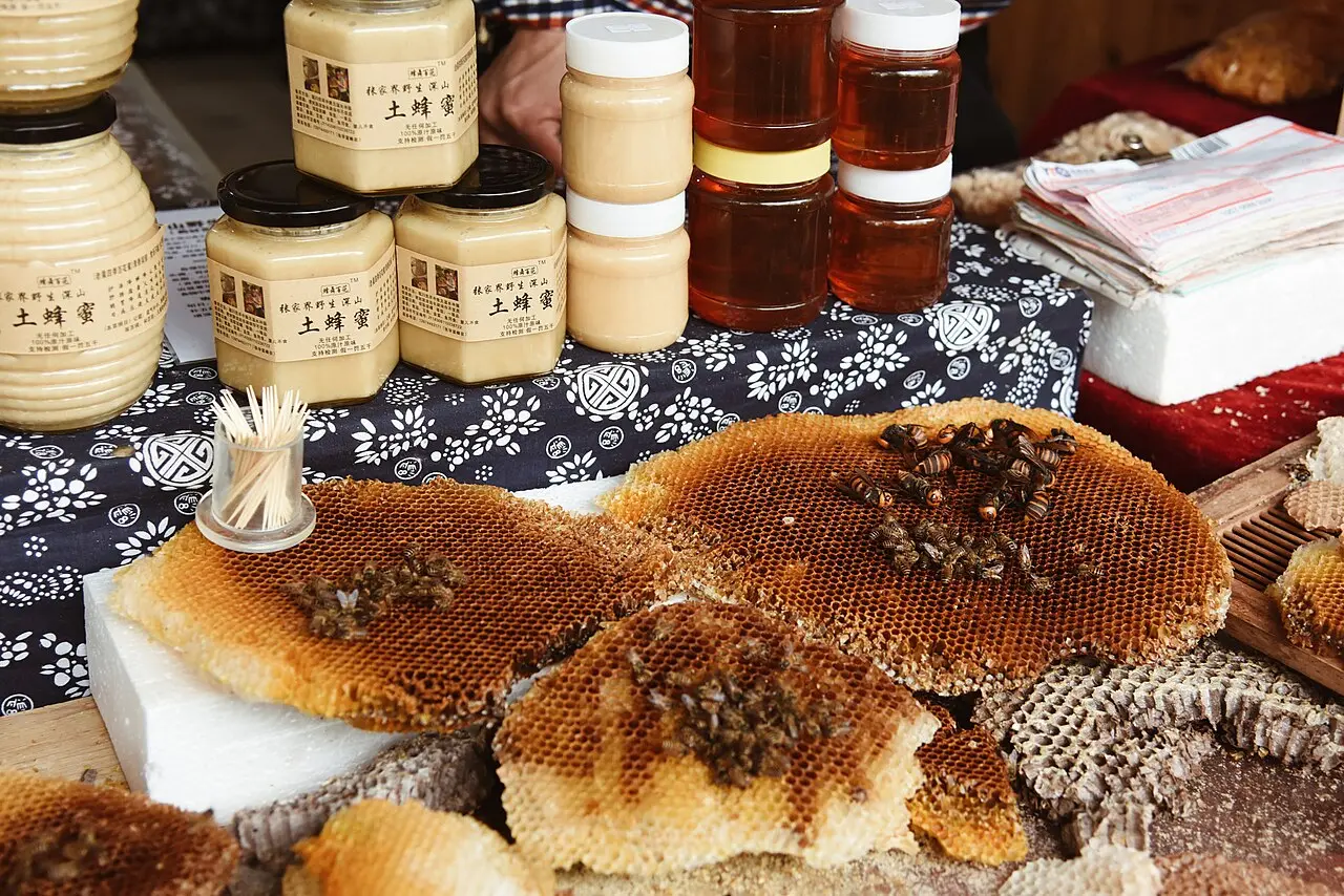 Jars of raw honey displayed for sale on a vendor table