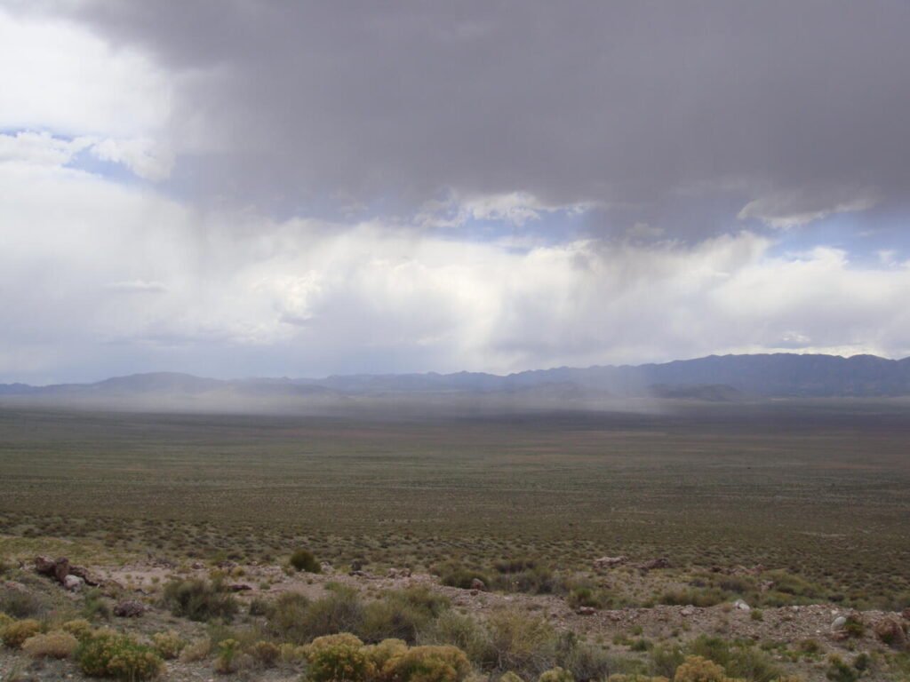 A localized summer rain storm over a valley, the kind of rainfall a regional forecast can miss entirely