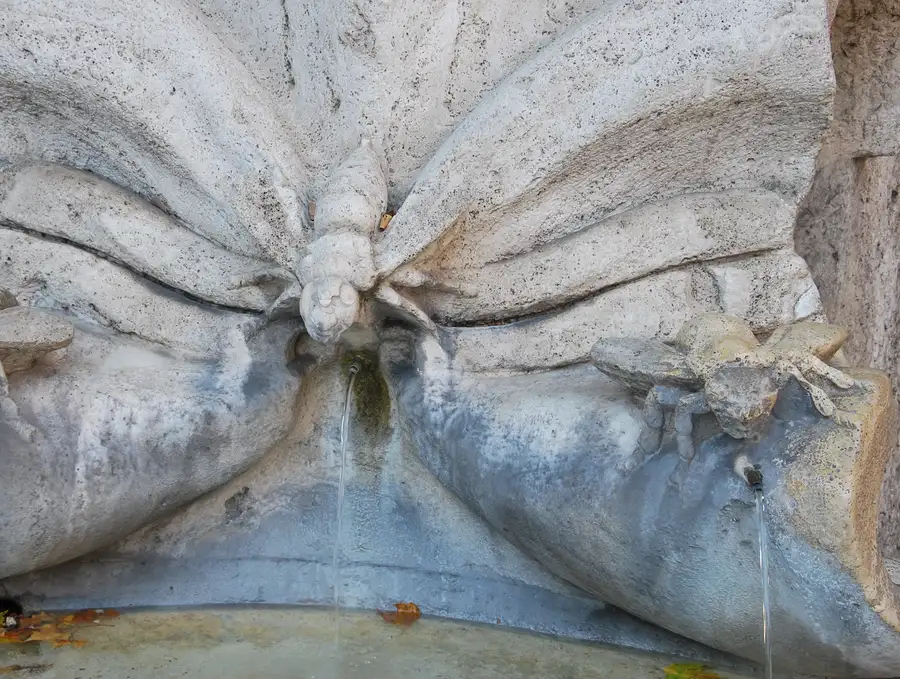 Stone bees on the Fontana delle Api, Bernini's Barberini fountain in Piazza Barberini, Rome, with water jets below